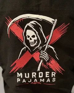 Close-up of the embroidered back art and Murder Pajamas MPx wordmark on the black gi after 20 washes
