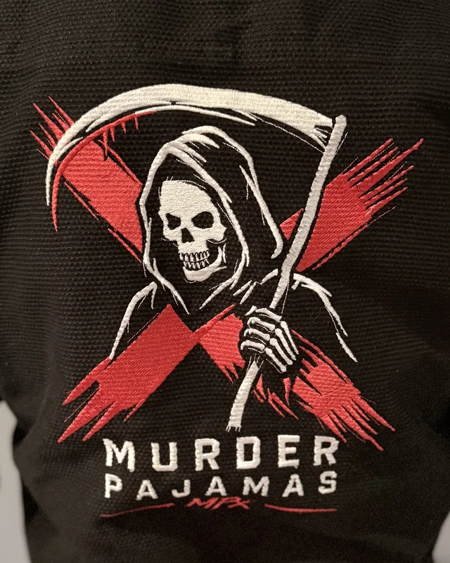 Close-up of the embroidered back art and Murder Pajamas MPx wordmark on the black gi after 20 washes
