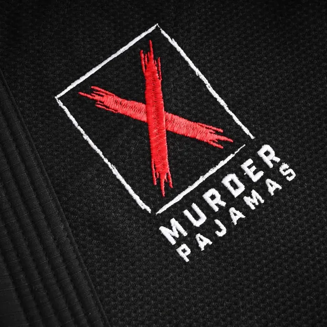 Embroidered red X and MURDER PAJAMAS logo on the black gi jacket skirt